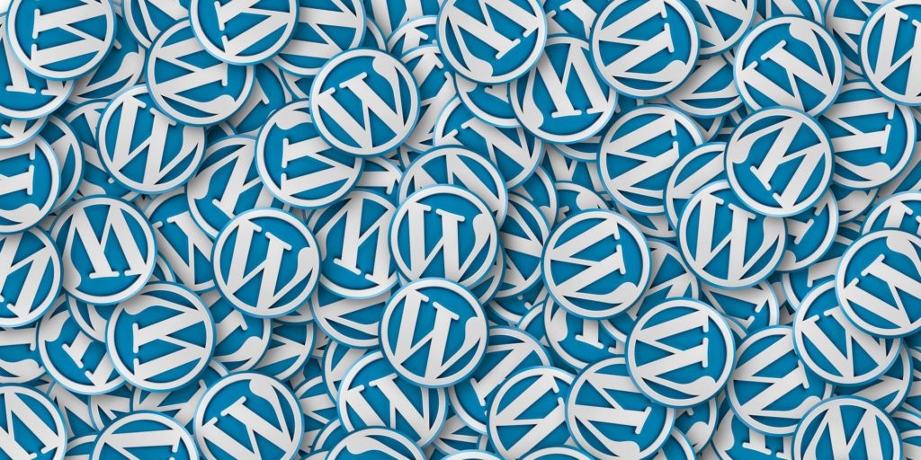 Photo of pile of badges with WordPress logo - is your WordPress site up-to-date?